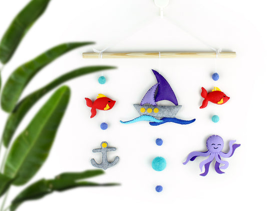 Colorful toy fish, sailboat, anchor, and octopus wall hanging made with felt for kids room decor