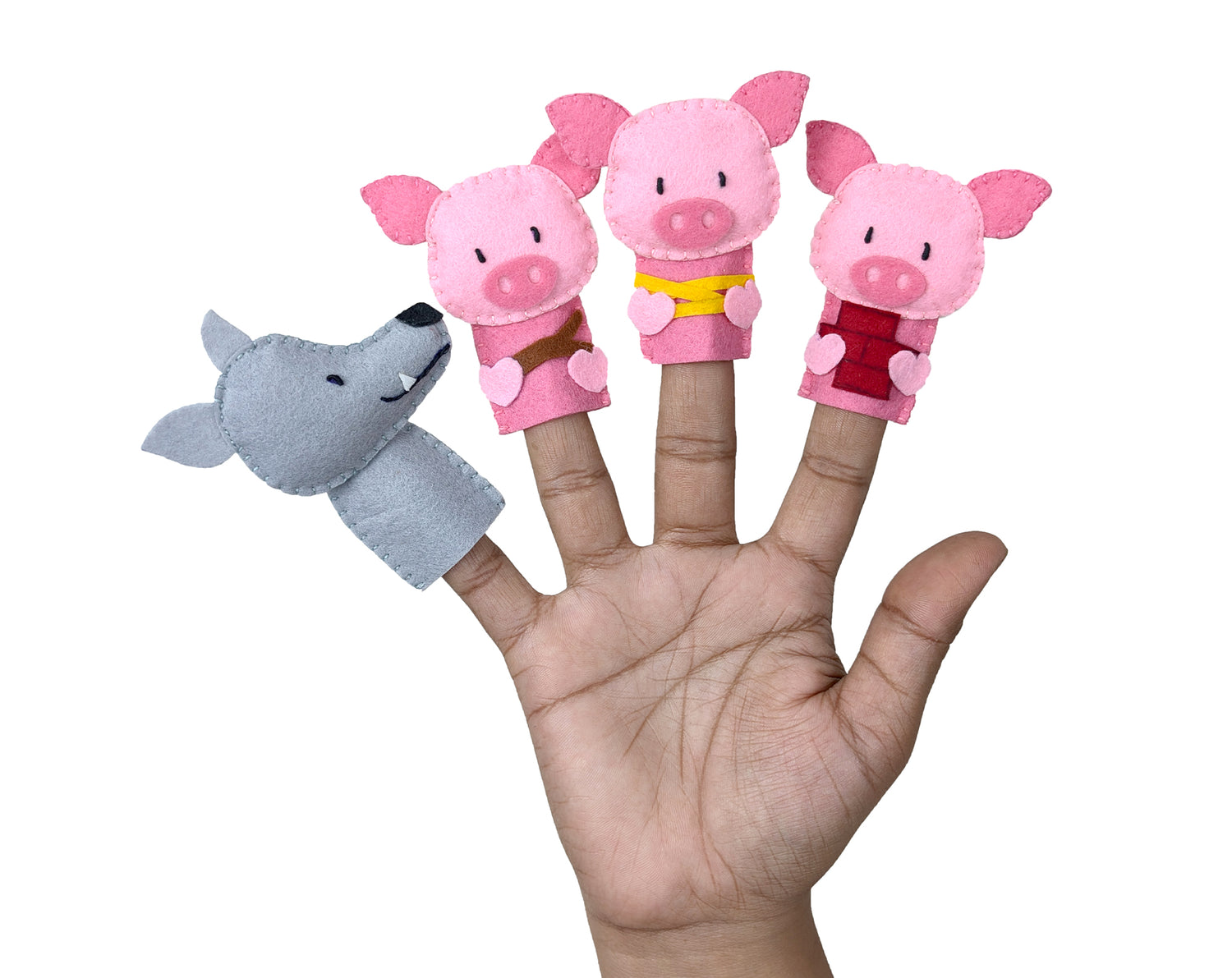 Finger puppets shaped like a wolf and three pigs on a hand against a white background